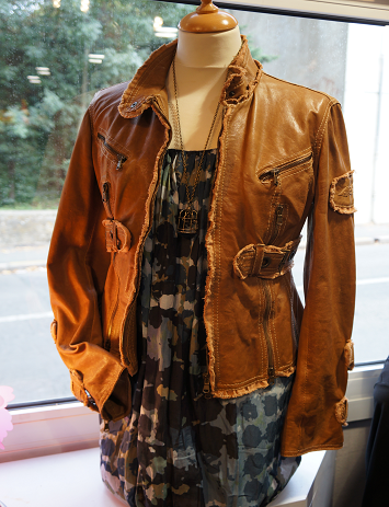 Veste en cuir camel présentée en vitrine